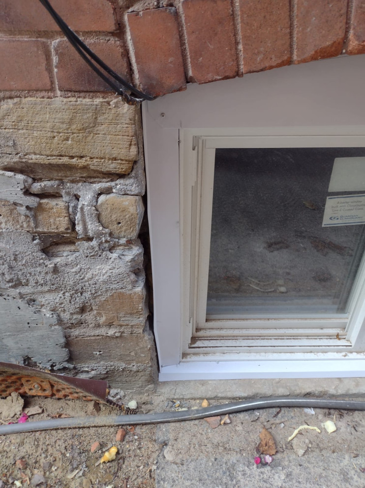 Gap between aluminum window trim and bricks.