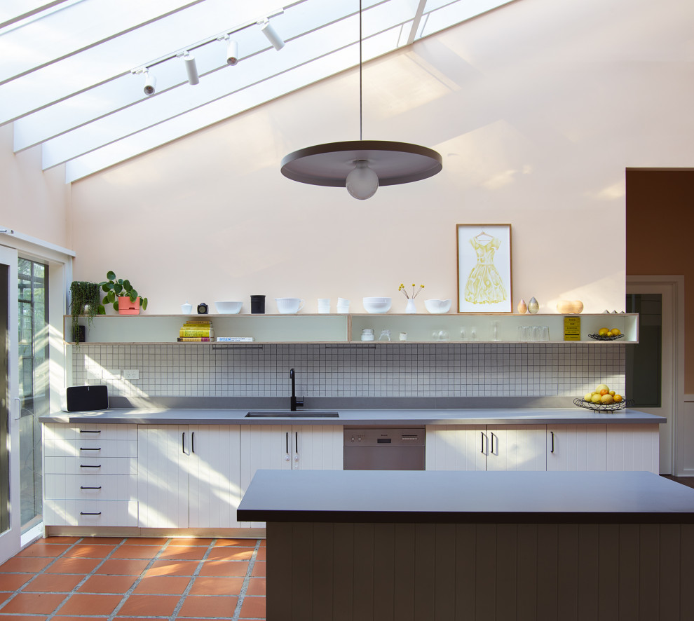 Transitional galley kitchen in Melbourne with an undermount sink, raised-panel cabinets, white cabinets, white splashback, stainless steel appliances, with island, brown floor, grey benchtop and vaulted.