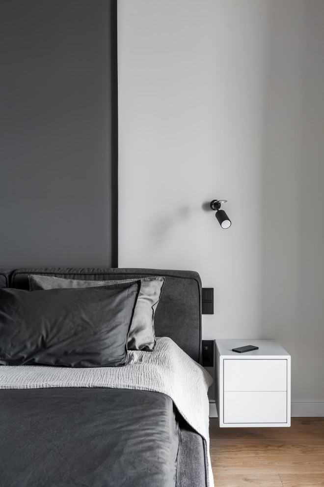 На фото: хозяйская спальня среднего размера в современном стиле с серыми стенами, полом из ламината и бежевым полом с