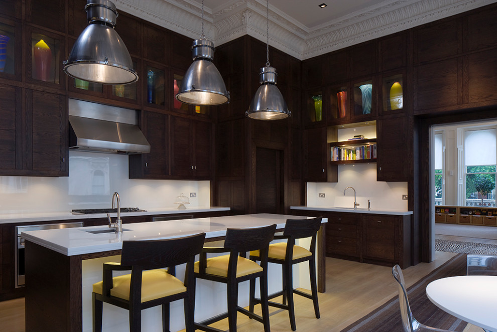 Inspiration for a large eclectic u-shaped eat-in kitchen in London with an undermount sink, flat-panel cabinets, dark wood cabinets, quartz benchtops, white splashback, stainless steel appliances, medium hardwood floors, with island, brown floor, white benchtop and coffered.