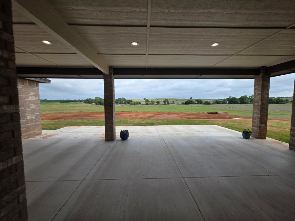 The covered patio features brick beams & can lighting
