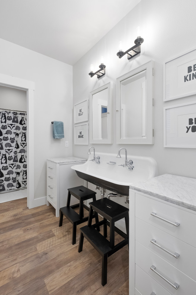 This is an example of a transitional kids bathroom in Other with flat-panel cabinets, white cabinets, grey walls, a trough sink, brown floor, grey benchtops, a double vanity and a freestanding vanity.