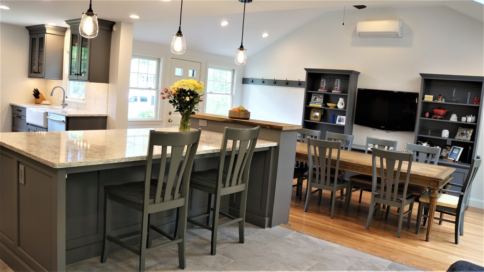 Mid-sized transitional galley porcelain tile and gray floor open concept kitchen photo in Boston with a farmhouse sink, recessed-panel cabinets, quartz countertops, white backsplash, porcelain backsplash, stainless steel appliances, an island and white countertops