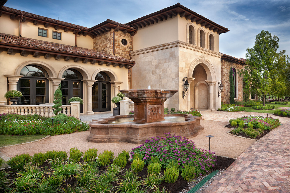 Photo of a mediterranean full sun garden in Houston with a water feature.