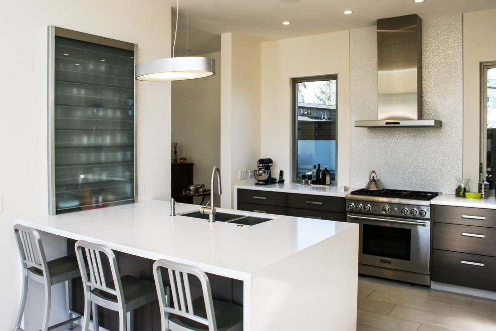 This is an example of a mid-sized contemporary galley eat-in kitchen in San Francisco with an undermount sink, flat-panel cabinets, dark wood cabinets, marble benchtops, white splashback, mosaic tile splashback, stainless steel appliances, porcelain floors and with island.