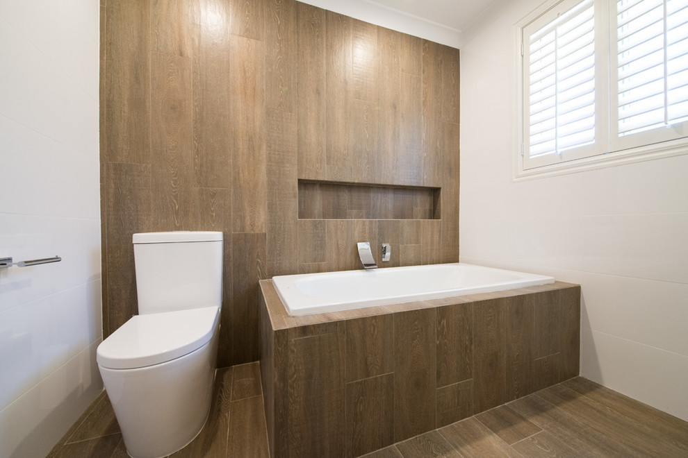 Mid-sized transitional master bathroom in Melbourne with flat-panel cabinets, grey cabinets, a drop-in tub, a one-piece toilet, brown tile, porcelain tile, white walls, porcelain floors, an undermount sink, engineered quartz benchtops, brown floor, white benchtops, a curbless shower and a hinged shower door.