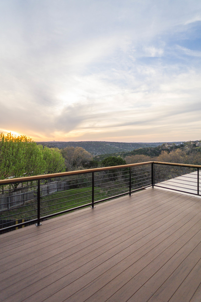 This is an example of a mid-sized contemporary backyard deck in Austin with a pergola.