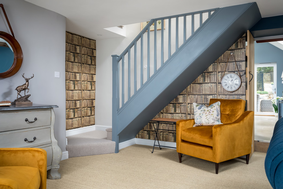 Photo of a mid-sized country carpeted straight staircase in Gloucestershire with carpet risers and wood railing.