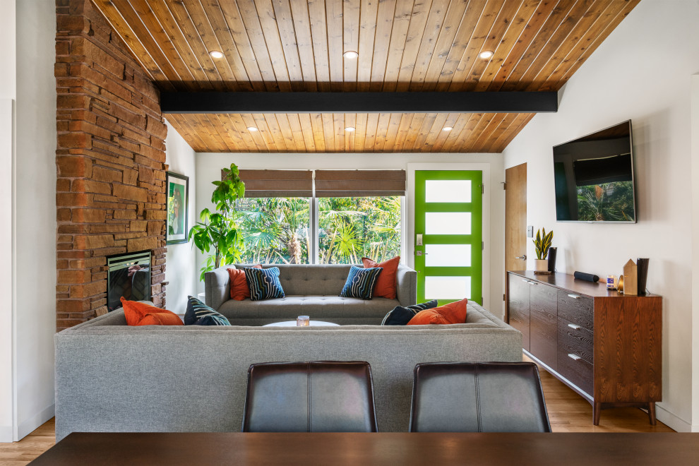 Foto di un soggiorno minimalista di medie dimensioni e aperto con pareti bianche, parquet chiaro, cornice del camino in pietra, TV a parete e soffitto in legno