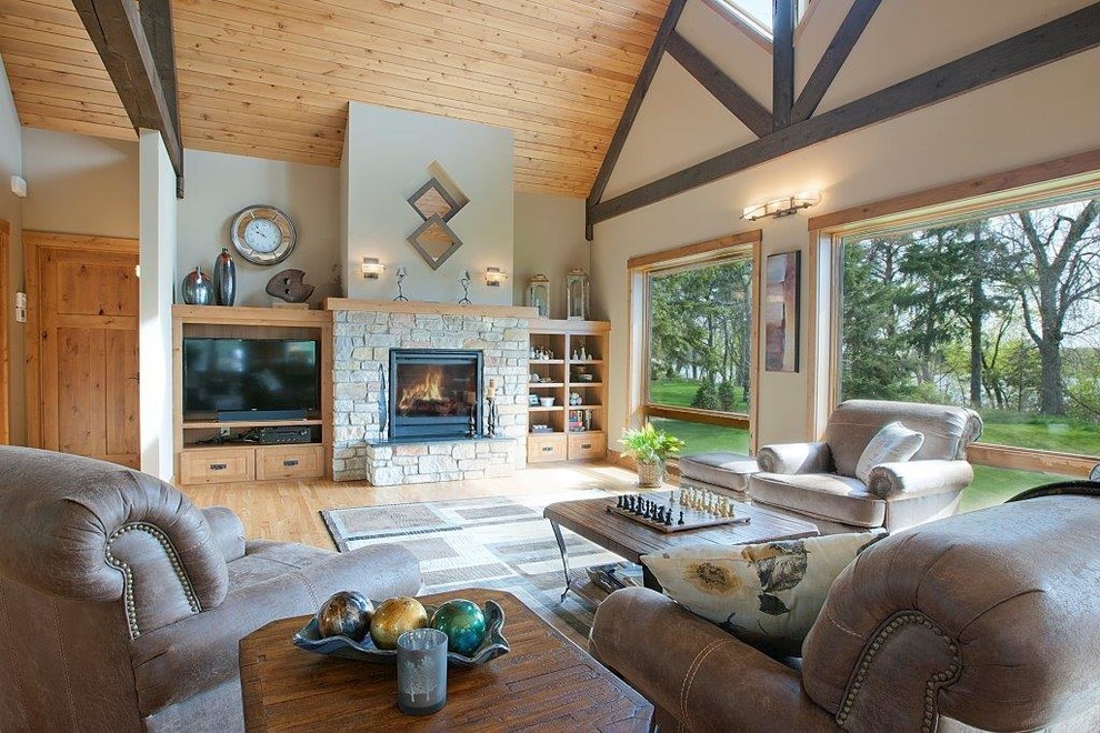 Large traditional open concept family room in Minneapolis with beige walls, light hardwood floors, a standard fireplace, a stone fireplace surround and a freestanding tv.
