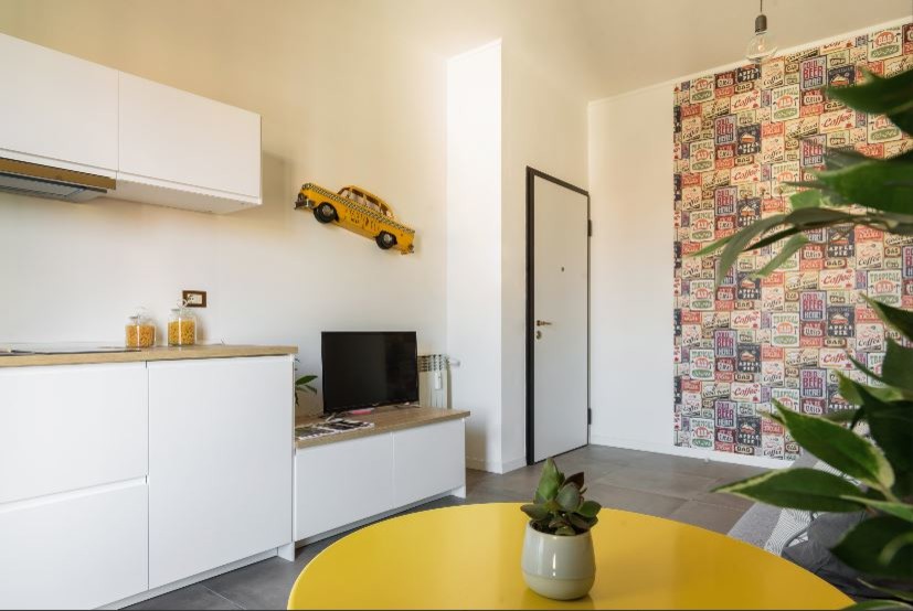 Photo of a small modern open concept living room in Milan with yellow walls, porcelain floors, a built-in media wall and grey floor.