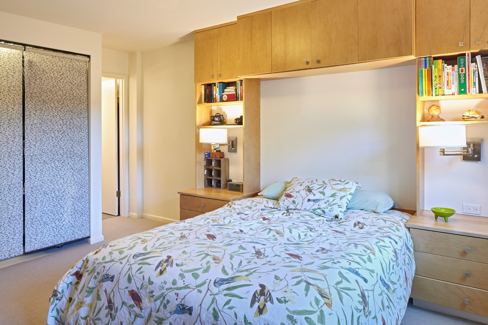 This is an example of a small contemporary master bedroom in Portland with white walls and carpet.