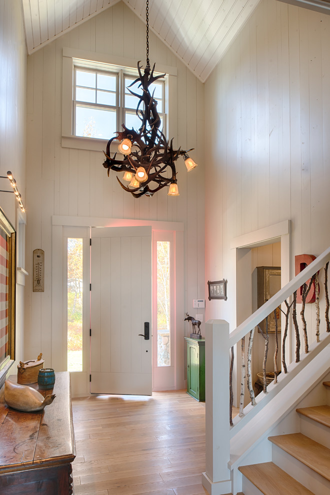 Photo of a beach style foyer in Minneapolis with white walls, light hardwood floors, a single front door and a white front door.