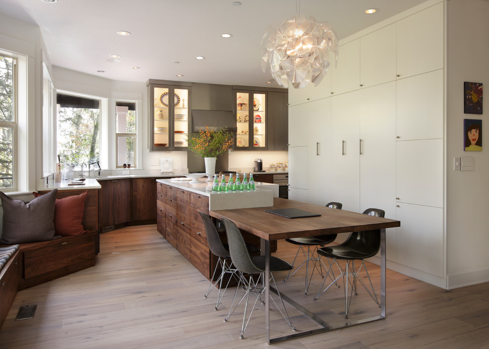 Inspiration for a large contemporary eat-in kitchen in Portland with an undermount sink, glass-front cabinets, quartz benchtops, white splashback, stone slab splashback, stainless steel appliances, medium hardwood floors and with island.