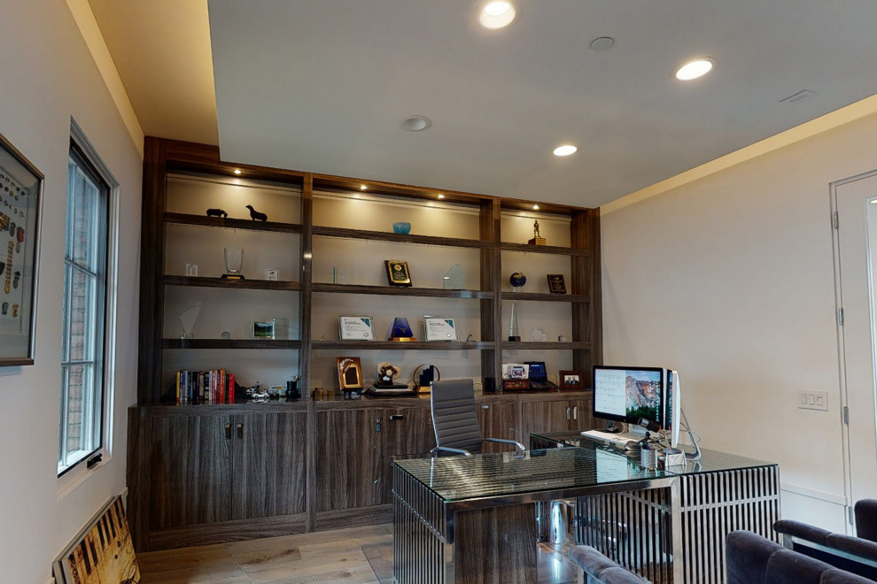 Home office - large modern freestanding desk medium tone wood floor, brown floor and tray ceiling home office idea in Orange County with beige walls