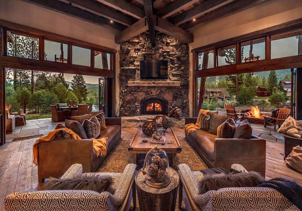 Photo of a country open concept living room in Sacramento with brown walls, dark hardwood floors, a corner fireplace, a stone fireplace surround and a wall-mounted tv.