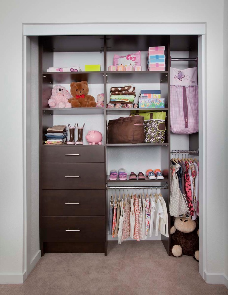 Design ideas for a small transitional women's built-in wardrobe in Denver with flat-panel cabinets, dark wood cabinets and carpet.