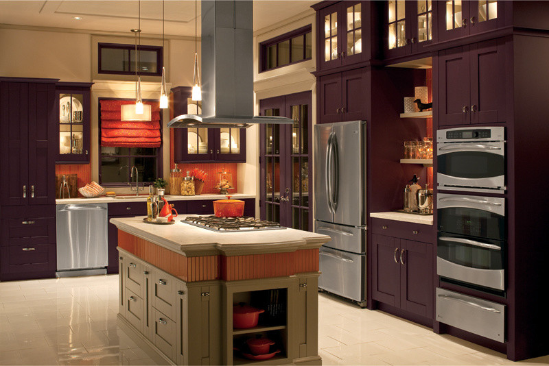 Photo of a large traditional l-shaped eat-in kitchen in New York with a drop-in sink, shaker cabinets, purple cabinets, solid surface benchtops, orange splashback, mosaic tile splashback, stainless steel appliances, ceramic floors, with island and beige floor.
