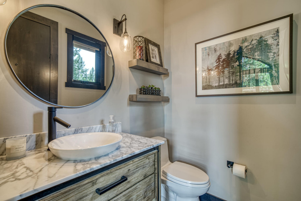 Photo of a rustic cloakroom in Boise with freestanding cabinets, a one-piece toilet, grey walls, a vessel sink, marble worktops, white worktops and a freestanding vanity unit.