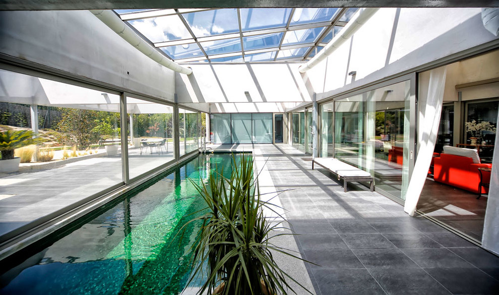 Large contemporary sunroom in Madrid with ceramic floors, a glass ceiling and no fireplace.
