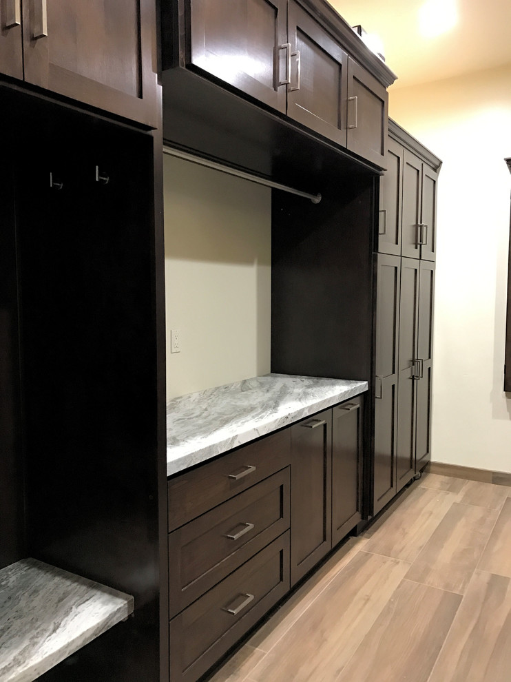 Expansive dedicated laundry room in Los Angeles with an undermount sink, shaker cabinets, dark wood cabinets, marble benchtops, ceramic floors and a side-by-side washer and dryer.