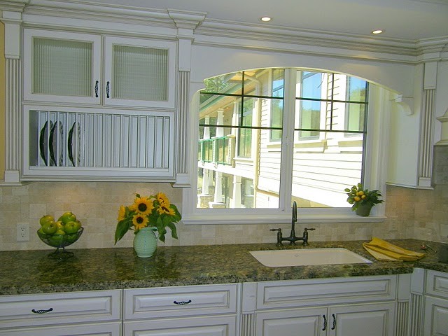 This is an example of a traditional u-shaped eat-in kitchen in Vancouver with an undermount sink, raised-panel cabinets, white cabinets, granite benchtops, beige splashback and panelled appliances.