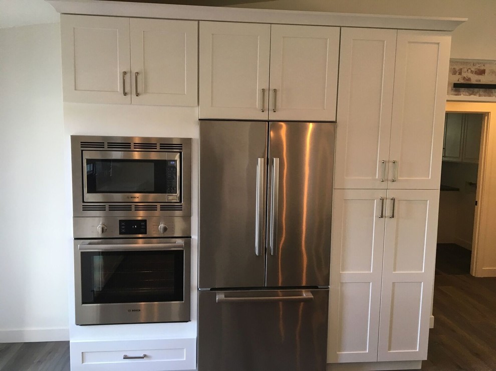 Inspiration for a mid-sized transitional medium tone wood floor and brown floor kitchen remodel in Phoenix with shaker cabinets, white cabinets and stainless steel appliances
