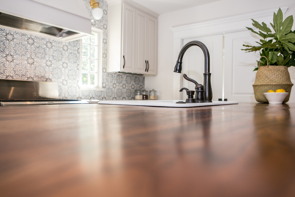 Mid-sized cottage single-wall brown floor and medium tone wood floor eat-in kitchen photo in Atlanta with gray cabinets, blue backsplash, terra-cotta backsplash, stainless steel appliances, an island, a drop-in sink, shaker cabinets and quartz countertops