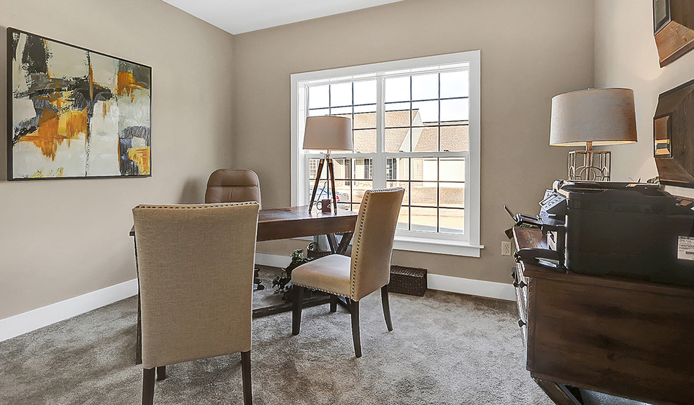 This is an example of a mid-sized transitional study room in Other with beige walls, carpet, no fireplace and a freestanding desk.