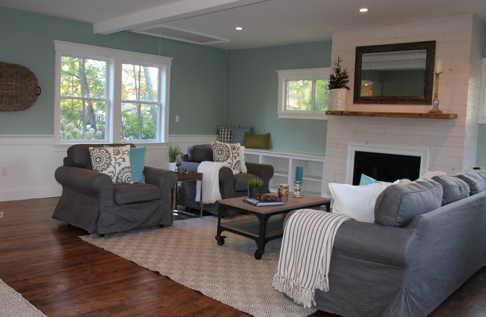 This is an example of a large country open concept family room in Boston with blue walls, medium hardwood floors, a standard fireplace and a wood fireplace surround.