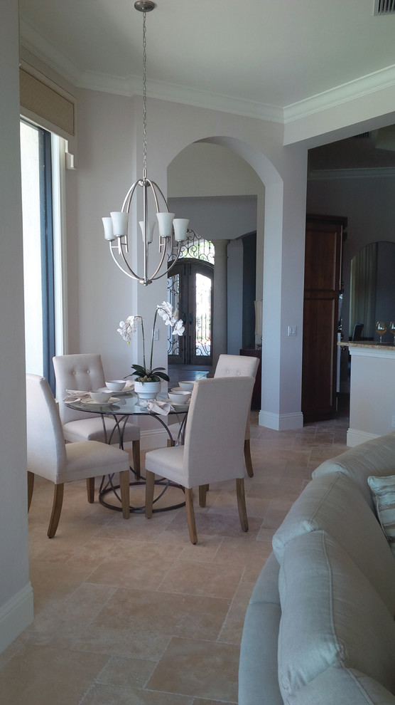 Photo of a mid-sized mediterranean kitchen/dining combo in Miami with beige walls, travertine floors and no fireplace.
