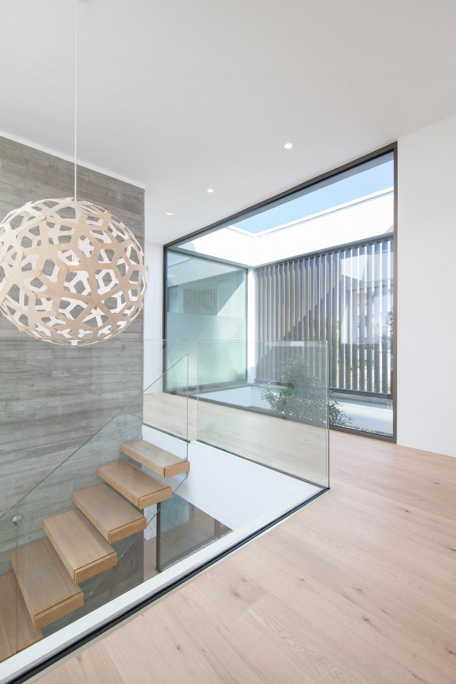 Moderner Flur mit weißer Wandfarbe und braunem Holzboden in Frankfurt am Main