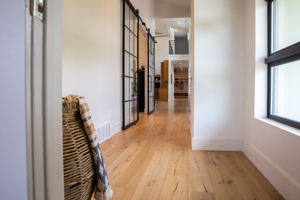 Example of a country light wood floor and white floor hallway design in Salt Lake City