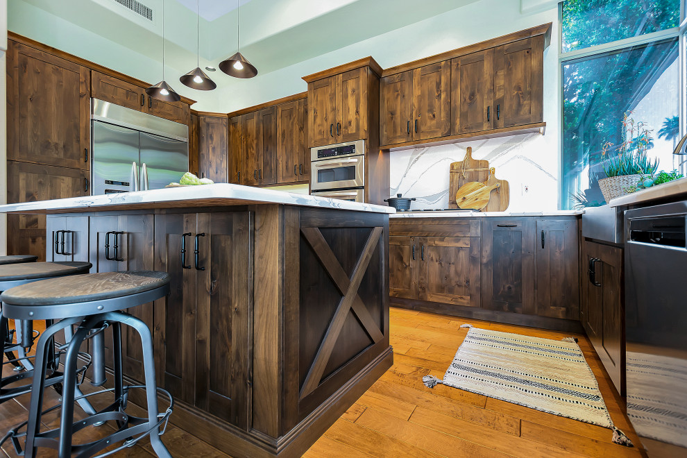 Example of a large transitional u-shaped open concept kitchen design in Phoenix with a farmhouse sink, shaker cabinets, dark wood cabinets, quartz countertops, white backsplash, quartz backsplash, stainless steel appliances, an island and white countertops