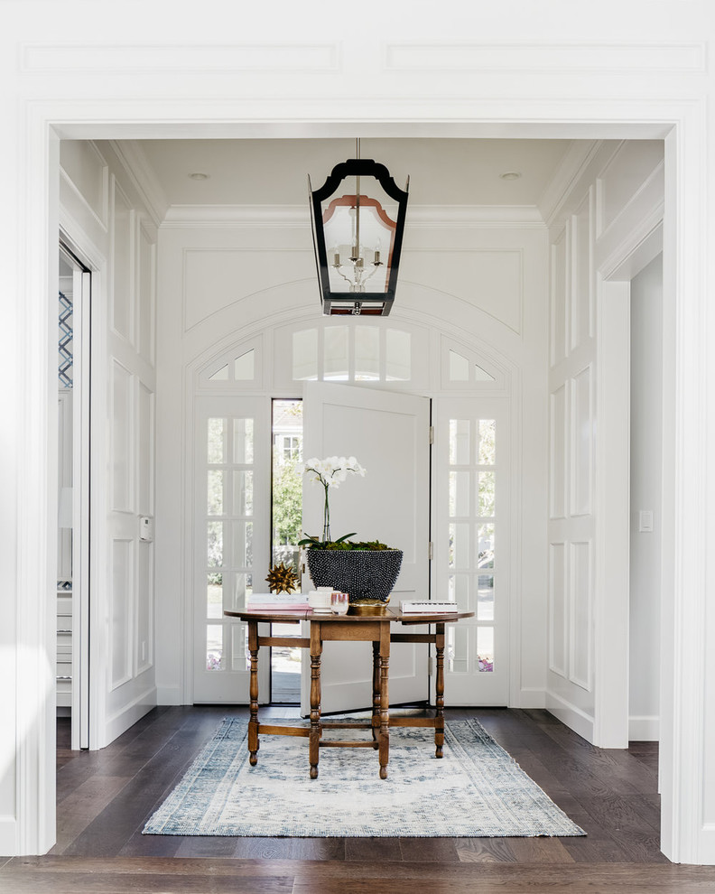 This is an example of a mid-sized transitional foyer in San Francisco with white walls, dark hardwood floors and a single front door.