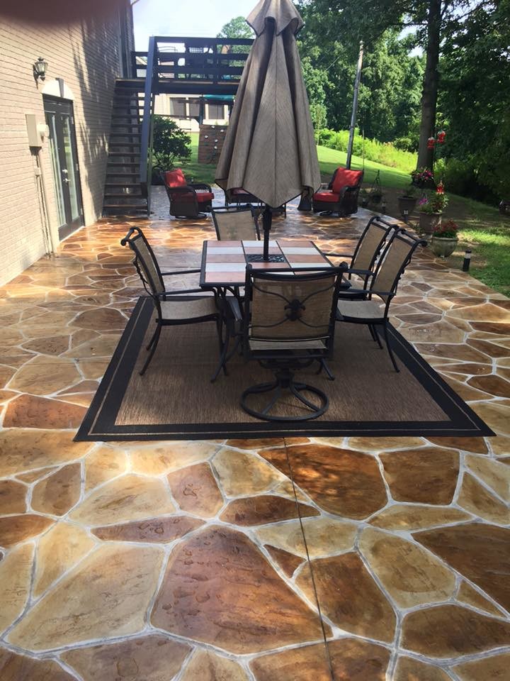 This is an example of a large traditional backyard patio in Cincinnati with stamped concrete and no cover.