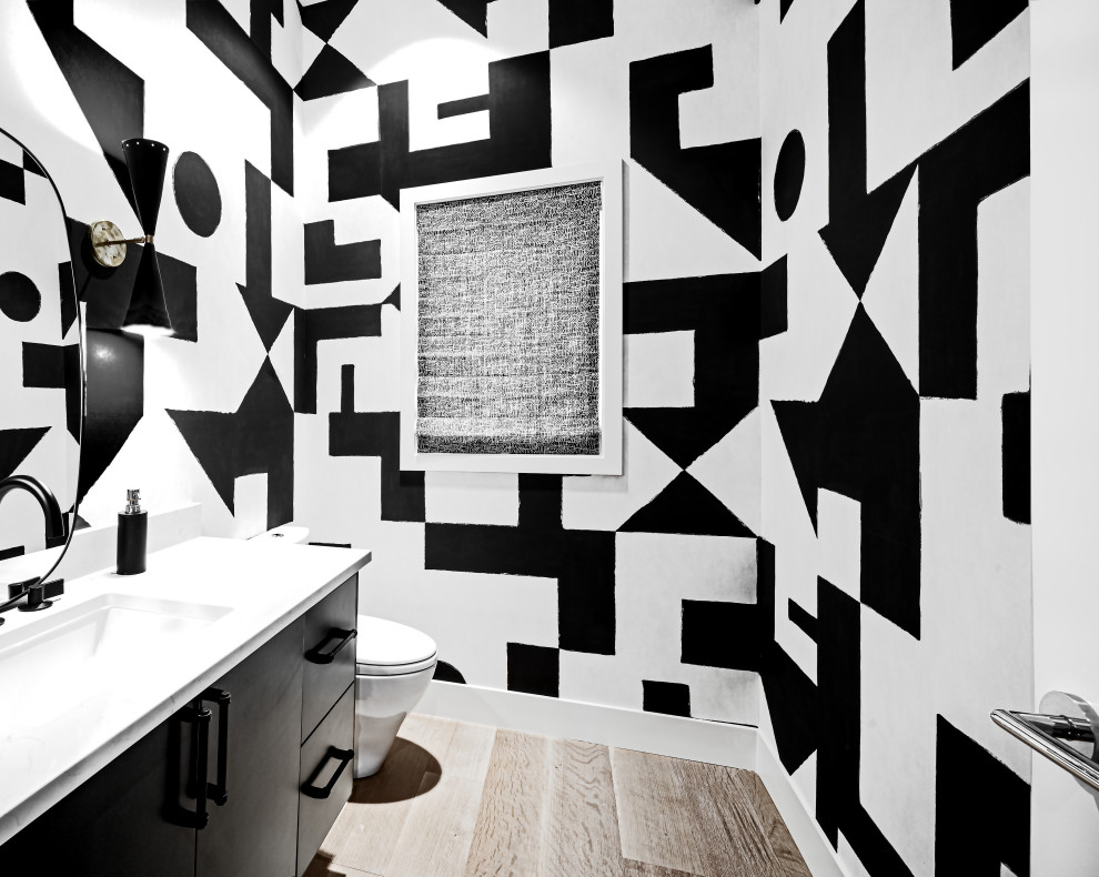 This is an example of a contemporary powder room in Seattle with flat-panel cabinets, black cabinets, multi-coloured walls, an undermount sink, brown floor, white benchtops and a floating vanity.