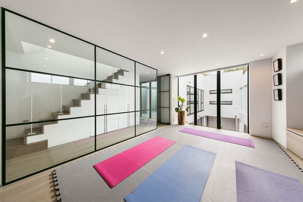 Design ideas for a contemporary home yoga studio with white walls and beige floor.