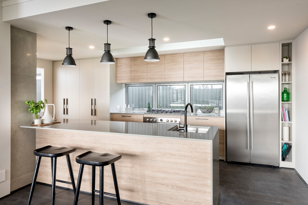 Inspiration for a contemporary galley separate kitchen with an undermount sink, flat-panel cabinets, light wood cabinets, window splashback, stainless steel appliances, dark hardwood floors, with island and grey floor.