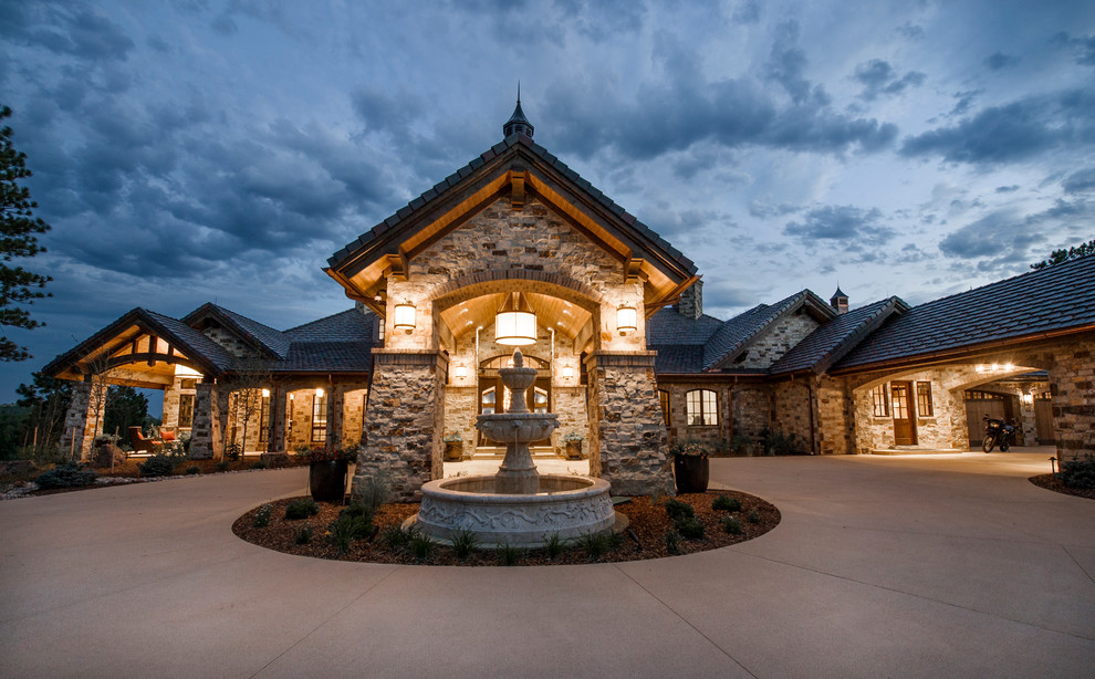 Inspiration for an expansive country two-storey exterior in Denver with stone veneer.
