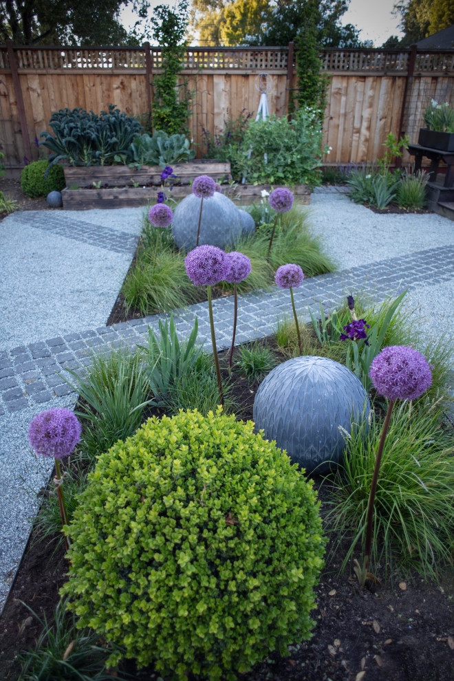 Ejemplo de jardín actual pequeño en patio trasero con parterre de flores, exposición parcial al sol y adoquines de piedra natural
