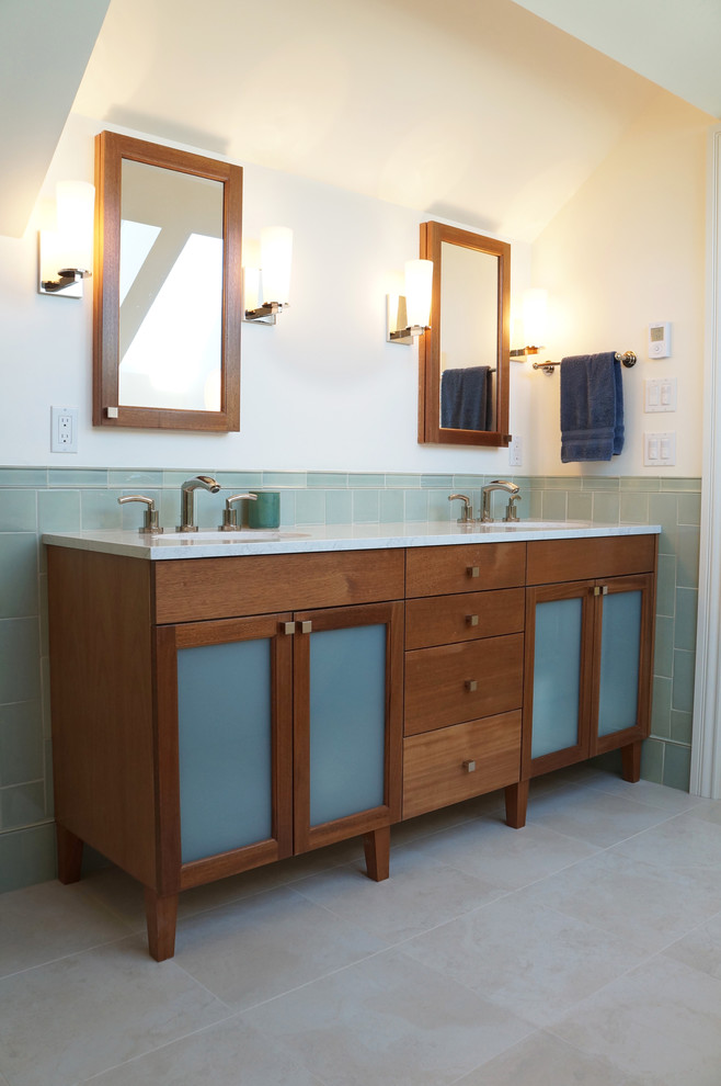 Photo of a contemporary bathroom in San Francisco with glass-front cabinets, beige cabinets, solid surface benchtops, ceramic tile and porcelain floors.