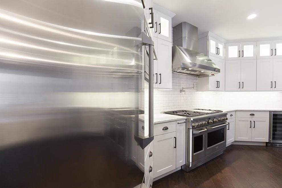 Example of a large transitional medium tone wood floor eat-in kitchen design with an undermount sink, shaker cabinets, white cabinets, quartzite countertops, white backsplash, subway tile backsplash, stainless steel appliances and an island