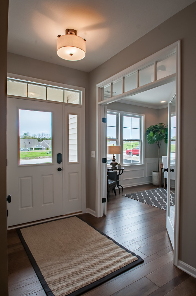 Inspiration for a mid-sized contemporary front door in Cincinnati with beige walls, medium hardwood floors, a single front door, a red front door and brown floor.