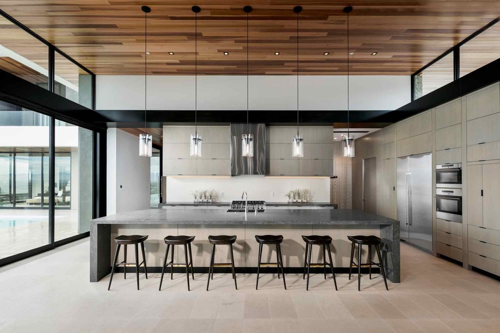 Design ideas for an expansive contemporary kitchen in Phoenix with an undermount sink, flat-panel cabinets, light wood cabinets, white splashback, stainless steel appliances, with island and beige floor.