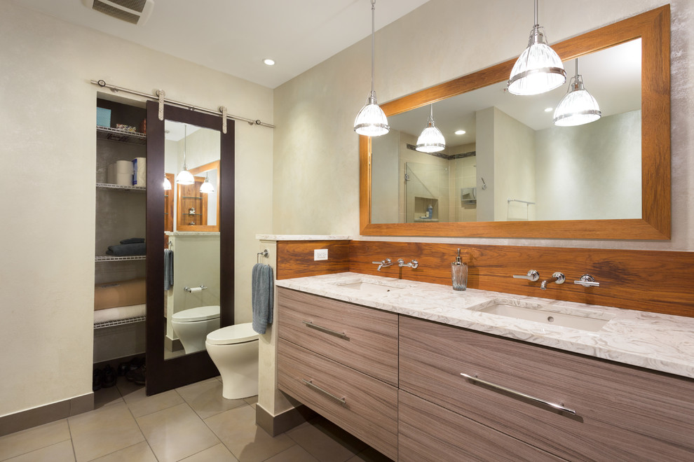 Inspiration for a mid-sized transitional master bathroom in Chicago with flat-panel cabinets, medium wood cabinets, an alcove tub, an alcove shower, a two-piece toilet, white tile, ceramic tile, white walls, ceramic floors, an undermount sink and marble benchtops.