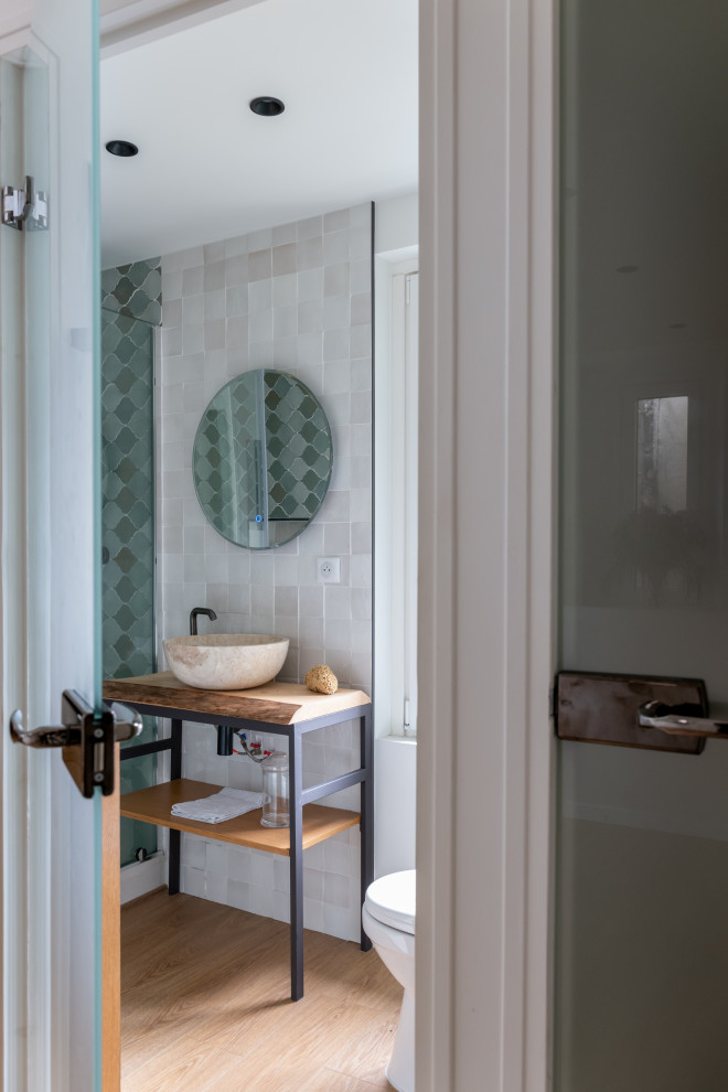Photo of a small mediterranean shower room bathroom in Paris with a one-piece toilet, green tiles, green walls, light hardwood flooring, a built-in sink, wooden worktops, a sliding door, a wall niche and a single sink.