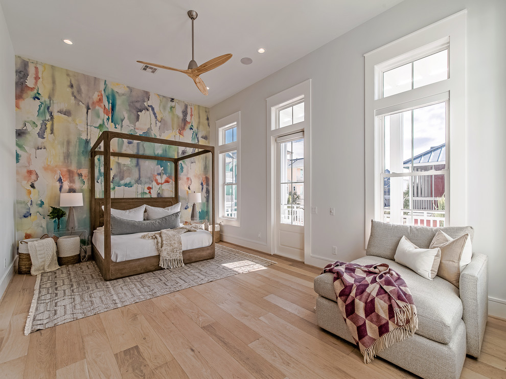 Beach style bedroom in Houston with multi-coloured walls and light hardwood floors.