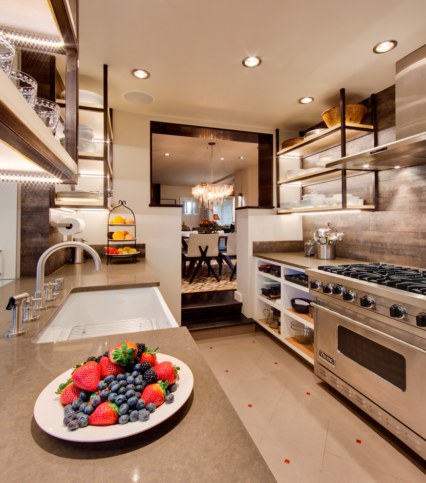 This is an example of a mid-sized galley kitchen in Albuquerque with a farmhouse sink, open cabinets, white cabinets, solid surface benchtops, brown splashback, stainless steel appliances and ceramic floors.