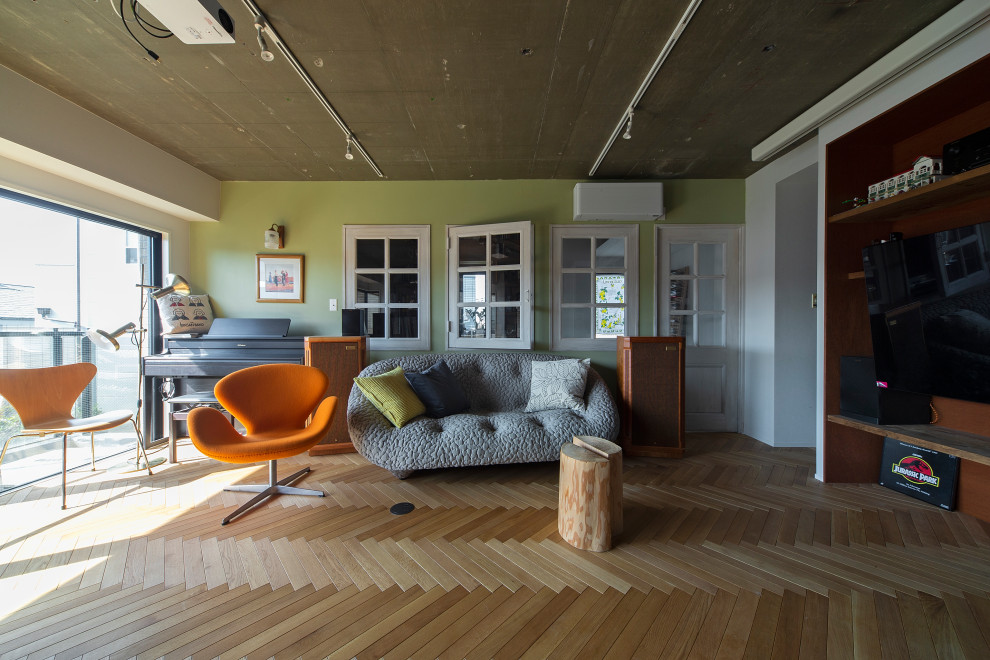 Cette photo montre un salon rétro ouvert avec un mur vert, un sol en bois brun, aucune cheminée, un téléviseur fixé au mur, un sol marron et poutres apparentes.